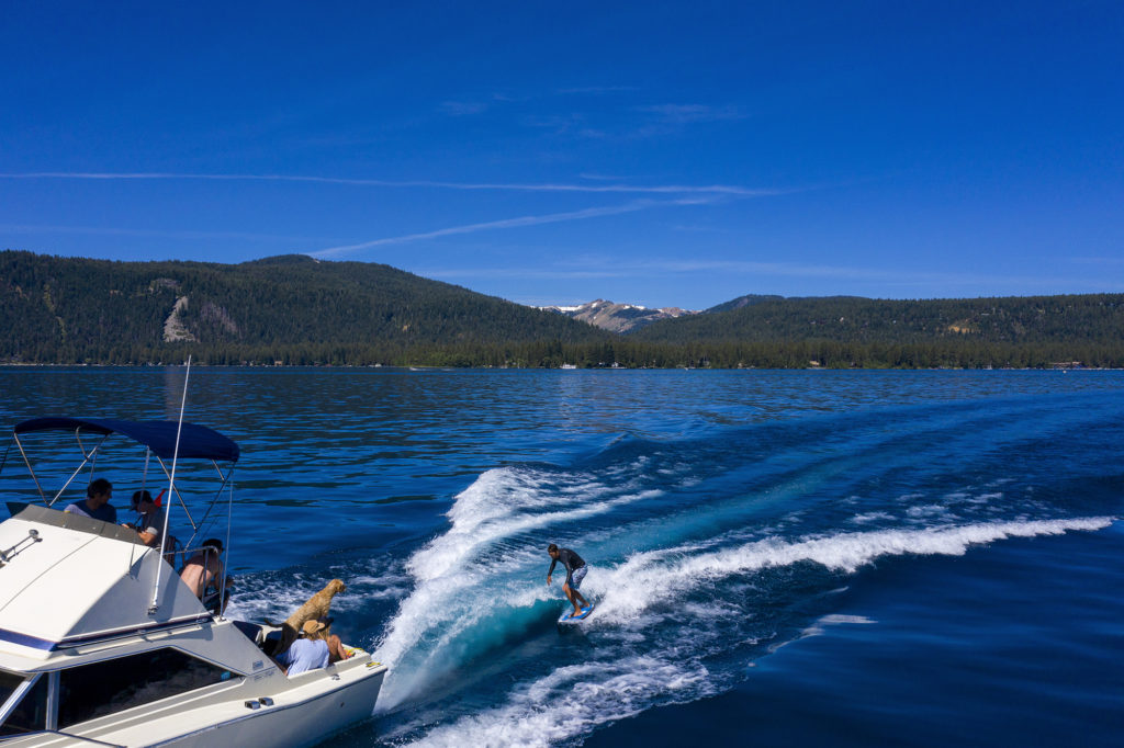 Friends enjoy boating and wake surfing on Lake Tahoe in summer