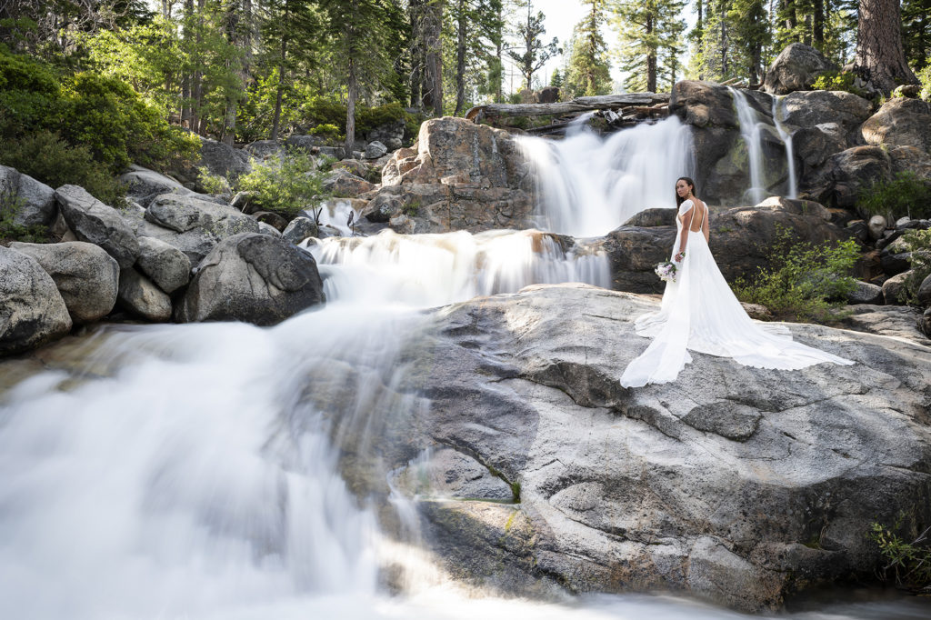 Bride posing in front of a waterfall at Squaw Valley's Shirley Lake Trail