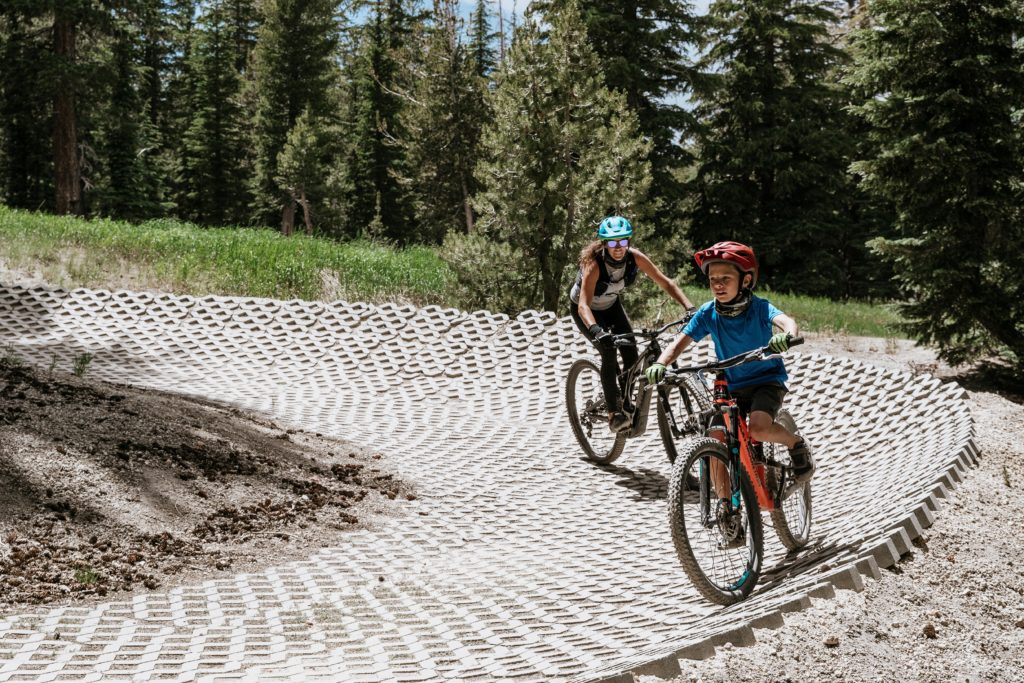 Woman and child riding mountain bikes on a trail in Mammoth Mountain's bike park